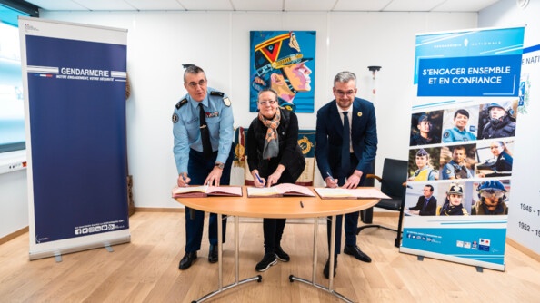 Entourés de deux kakémonos de la gendarmerie nationale, de gauche à droite : le général de division Christophe Boyer, adjoint au directeur des personnels militaires, Catherine Tripon et Benjamin Vodant, respectivement porte-parole et secrétaire général et de L’Autre Cercle, le mardi 28 février 2023, à la direction générale de la gendarmerie nationale, signent ensemble sur une table ronde la charte d’engagement LGBT+.