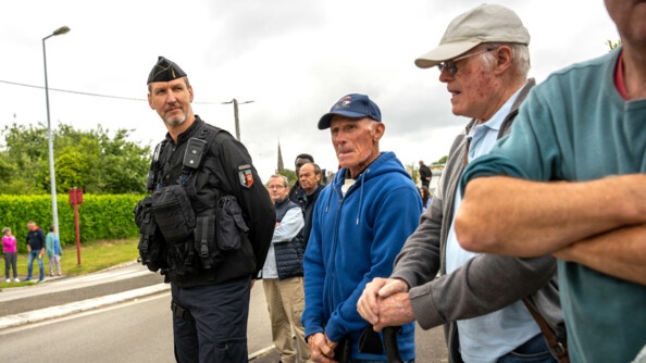Un gendarme mobile sécurise le rond point où passe l'escorte présidentielle avec des habitants de Plumelec aux alentours