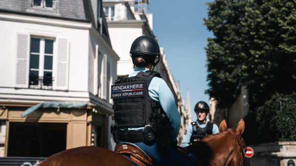 Photo de deux cavaliers de la garde r&eacute;publicaine sur leur monture dans les rues de Paris. La photo est prise en journ&eacute;e, par beau temps. le ciel est bleu.