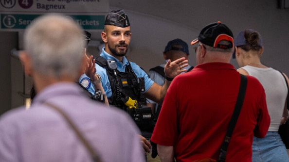 Un gendarme renseigne des passagers dans le métro parisien.