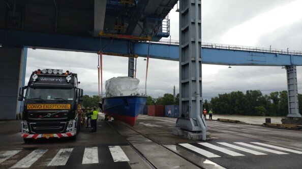 La nouvelle vedette de la compagnie fluviale franco-allemande entrain d'être descendue du camion sur le sol.