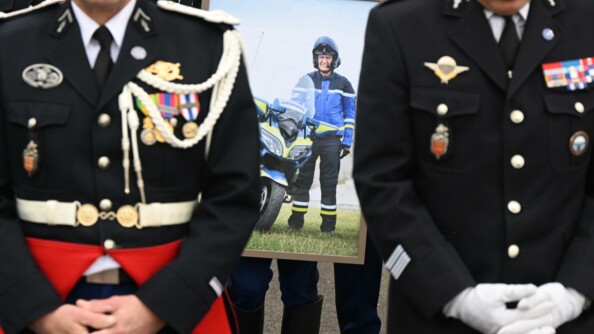 Portrait de l'adjudant-chef Allek Bellaïd, en tenue avec sa moto, entouré par des gendarmes