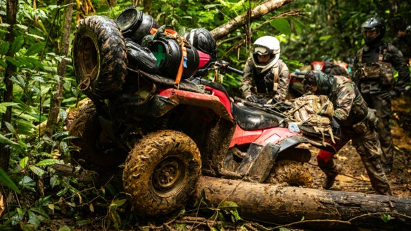 Gendarmes poussant un quad au dessus d'un tronc.
