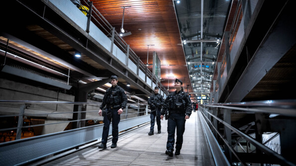 Une patrouille de trois gendarmes mobiles patrouillent sur un escalier plat dans une gare