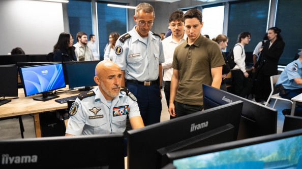 Deux g&eacute;n&eacute;raux pris de face sont sur un ordinateur en train de d&eacute;couvrir la nouvelle plateforme. A c&ocirc;t&eacute; d'eux, deux &eacute;l&egrave;ves regardent.