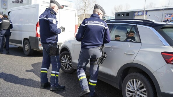 Deux motocyclistes de la gendarmerie à pieds effectuent un contrôle routier d'un break gris