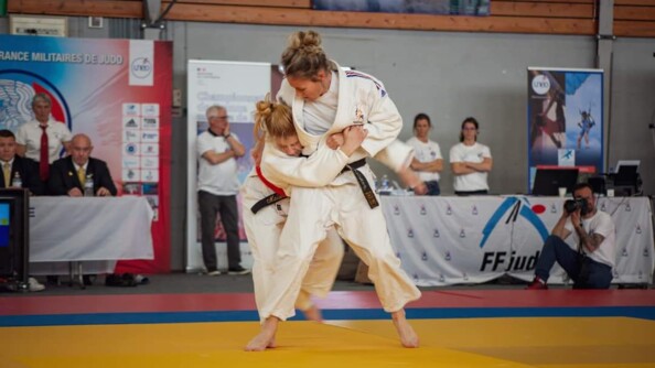 Deux judokates lors d'un combat sur un tatami jaune