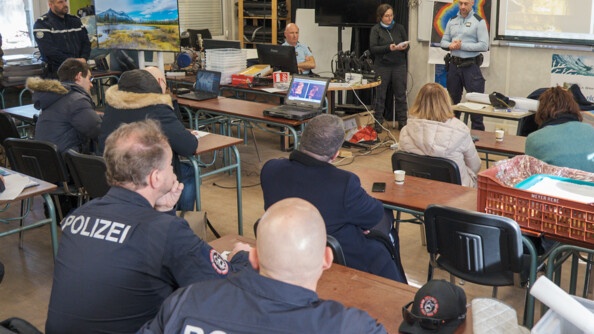 Dans une pièce ressemblant à une salle de classe, des plongeurs de la gendarmerie nationale, des plongeurs Suisse et Allemand, écoutent attentivement le directeur des opérations qui présente l'exercice qui va se dérouler.