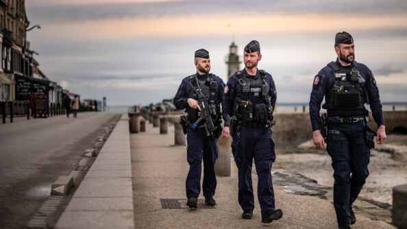 Trois gendarmes patrouillent le long de la jetée
