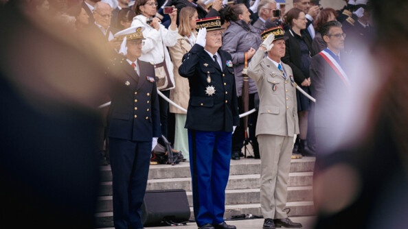 Le directeur général de la gendarmerie nationale se tient debout, face à une assemblée, effectuant un signe de salut militaire.