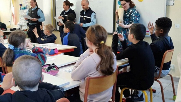 Trois gendarmes devant une classe d'élèves présentent le kit harcèlement