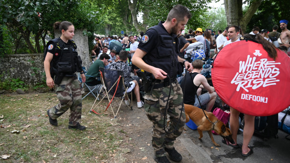 La photo représente des gendarmes (un homme et une femme), accompagnés d'un malinois, au milieu de la foule, à l'occasion du festival Garorock