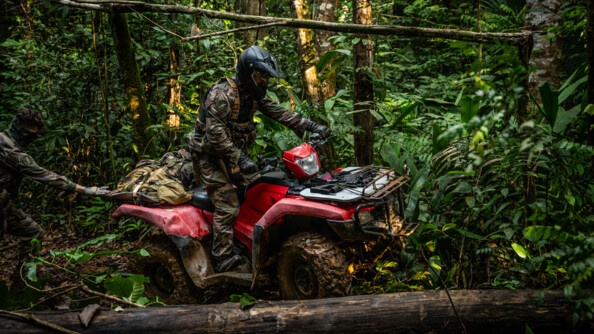 Militaire pilotant son quad à l'approche d'un tronc.