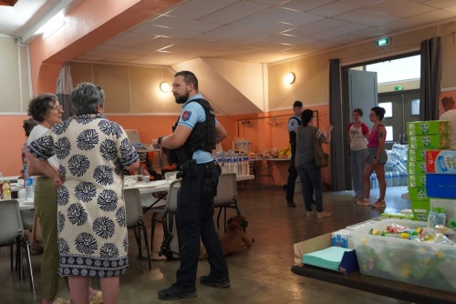 Un gendarme prend contact avec la population sinistr&eacute;e de l'incendie dans un centre d'h&eacute;bergement