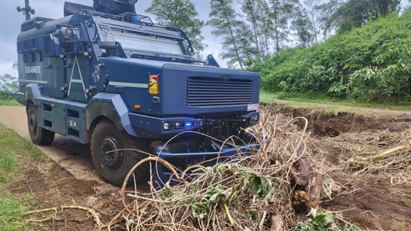 Un véhicule blindé de la gendarmerie déblaie une route barrée par des branches d'arbres arrachées, après le passage du cyclone Garance sur l'île de la Réunion.
