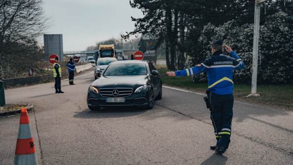 un gendarme oriente les voitures lors d'un controle sur une aire d'autoroute.