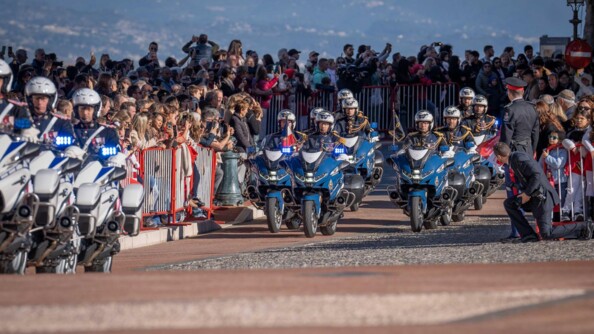 Neufs motards de la garde entourés de part et d'autre de la foule, avancent