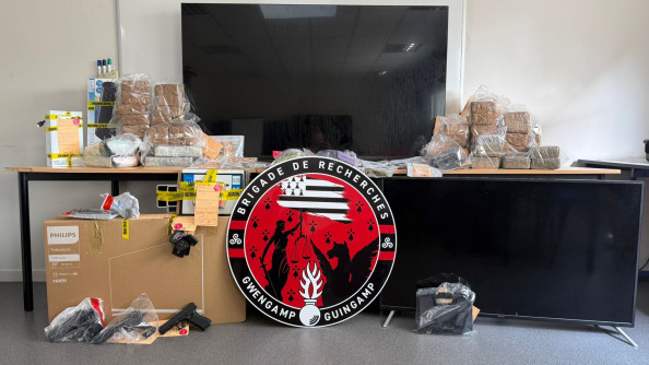 Des saisies sur des tables derrière un grand logo rouge et noir de la brigade de recherches de Guingamp