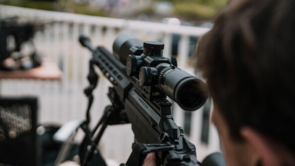 Tireur de la gendarmerie prêt à intervenir. Vue du canon de l'arme, le fond est flou.