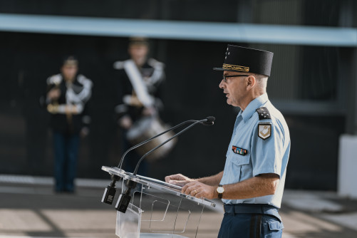 Un g&eacute;n&eacute;ral de gendarmerie effecte un discours au micro, derri&egrave;re un pupitre transparent. la sc&egrave;ne se d&eacute;roule en journ&eacute;e, dans une cour.