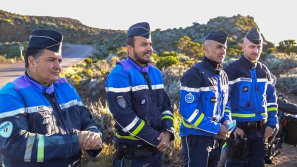 En ligne quatre gendarmes regardent la route.