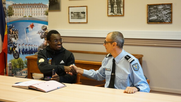 Lundi 23 octobre 2023, le colonel Philippe Bartolo, commandant par suppléance l'École de gendarmerie de Fontainebleau (à droite), a accueilli dans les rangs de la gendarmerie nationale le maréchal des logis Timmy Gillion (à gauche), cycliste sur piste, qui a signé son contrat de Sportif de haut niveau de la Défense – gendarmerie (SHND-G).