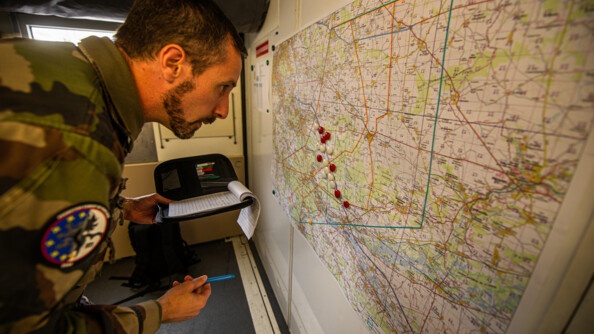 Un élèves-officiers à gauche, en train de planifier la manoeuvre avec une carte