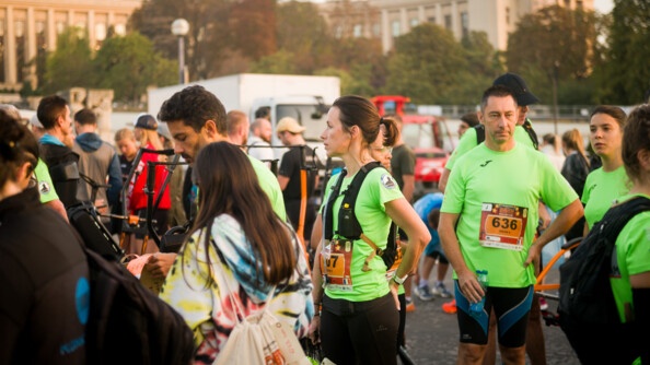 Des coureurs sont réunis dans l'attente du départ. Ils portent un t-shirt vert fluo