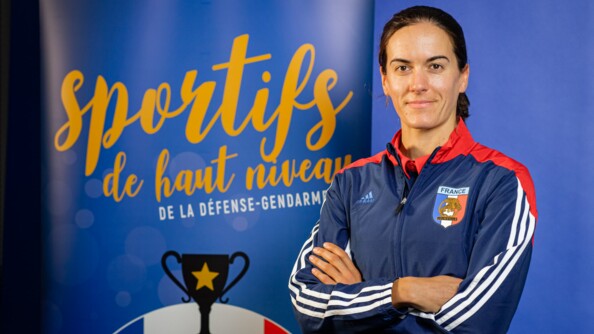 Margot Boulet en tenue de sportive de la gendarmerie devant un kakémono.