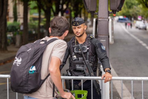 Un gendarme mobile discute avec un passant (on aperçoit ce dernier de dos)