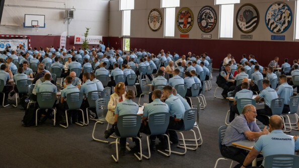 Des élèves gendarmes échangent avec les partenaires autour de tables rondes.