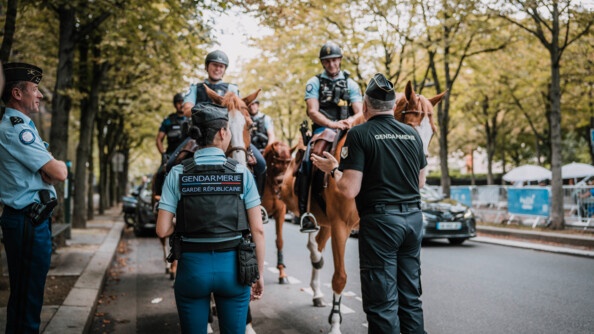 Le directeur général de la gendarmerie nationale,que l'on aperçoit ici de dos, discute avec des cavaliers, dans une rue de Paris.