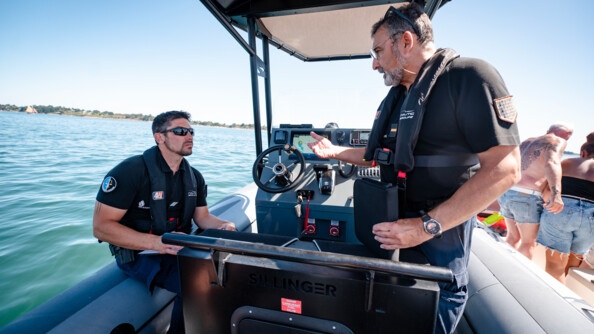 Deux gendarmes de la B.N. de Quiberon échangent à bord du semi-rigide de l'unité lors d'un contrôle en mer.