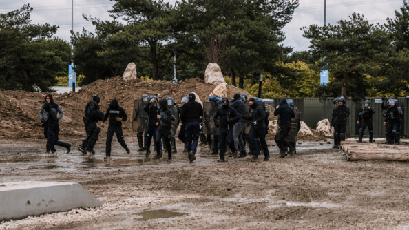 Une douzaine de plastrons affrontent un peloton de gendarmes mobiles dans un démonstration sur un terrain boueux