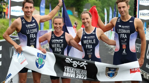 Photo de groupe de l'équipe militaire mixte française sur la ligne d'arrivée. Ils tiennent une banderole avec écrit dessus "triathlon brive 2023".