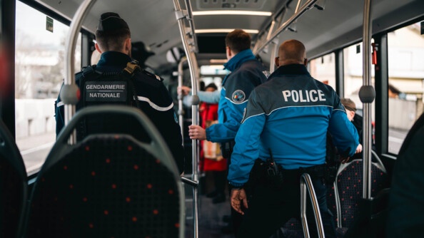 Un gendarme français et deux policiers suisses effectuent un contrôle des passagers dans un autobus.
