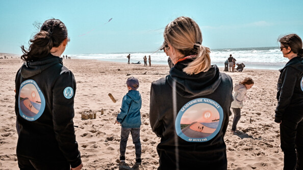 Deux participantes du stage Ad refectio sur la plage avec au second plan deux enfants qui jouent