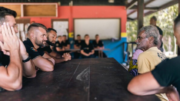 Gendarmes échangeant avec un membre de la tribu de Ouipoin autour d'une table.