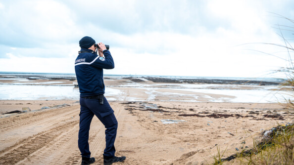 Militaire de la brigade nautique surveillant les exploitations ostréicoles à l'aide de ses jumelles.