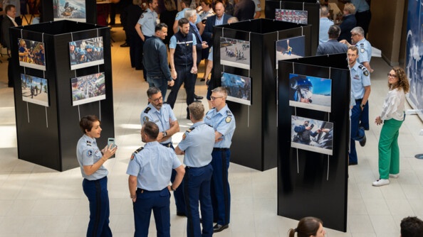 Vue d'ensemble de l'exposition sur le livre photo de la gendarmerie nationale. Les photos sont présentées et les personnes présentes sont en train de les découvrir.