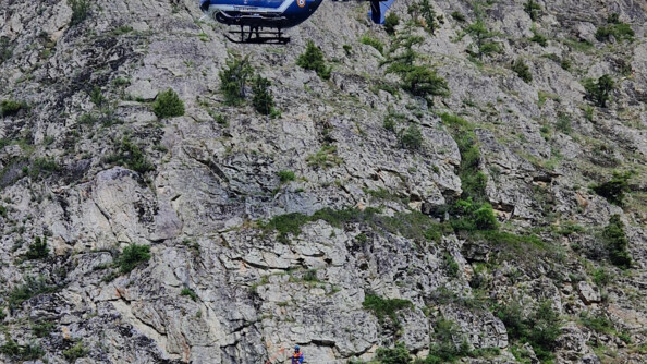 Un hélicoptère gendarmerie treuille deux personnes sur un victime en falaise lors d'un exercice