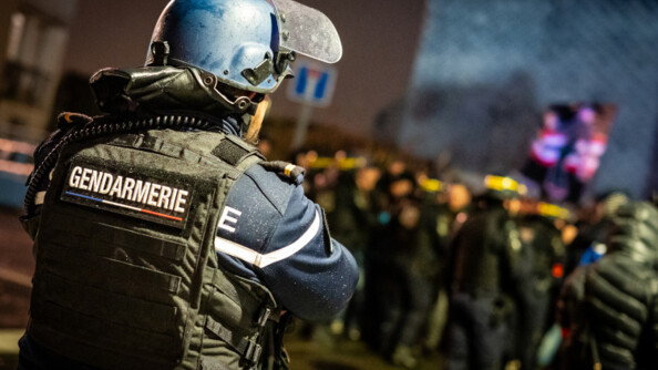 Gendarme de dos face à la foule.