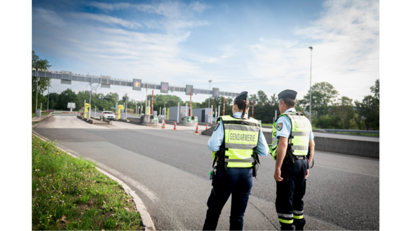 Deux gendarmes de dos devant un péage