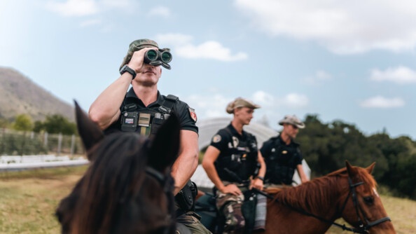 Gendarme du PSIC observant l'horizon à l'aide de jumelles.