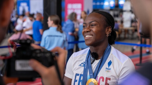 Clarisse Agbégnénou sur le stand du ministère de l'Intérieur et des Outre-mer au Club France avec ses deux médailles autour du cou.