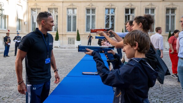 Le pentathlète moderne Christopher Patte à gauche, face à plusieurs tireurs sur le stand de tir, à l'hôtel Beauvau.