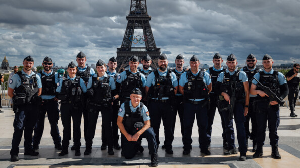 Des gendarmes posent devant la tour Eiffel lors des Jeux Olympiques.