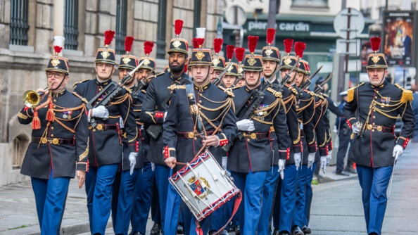 Militaires de la Garde républicaine avançant dans la rue lors de la grande relève. Le premier tient un tambour