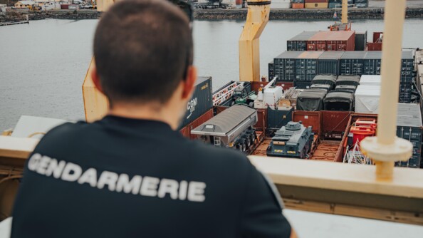 Arrivée de fret au port de Mayotte avec un gendarme de dos qui regarde
