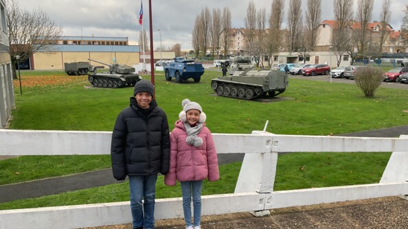 Les deux enfants se tenant devant des véhicules du GBGM.